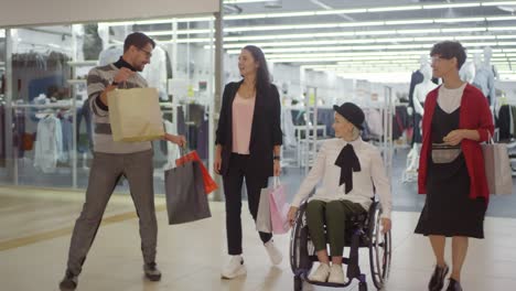 Happy-Woman-in-Wheelchair-and-her-Friends-Shopping-in-Mall