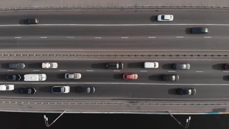 Highway-traffic-on-bridge-aerial-top-view-ascending-shot