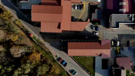 Aerial-Drone-Flight-top-view-at-the-street-with-houses-and-cars-that-move.-Roofs-of-houses-are-red-and-cars-that-move-down-the-street