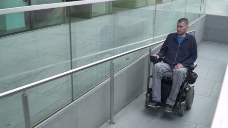 4k-resolution-follow-of-a-man-on-electric-wheelchair-using-a-ramp.-Accessibility-concept