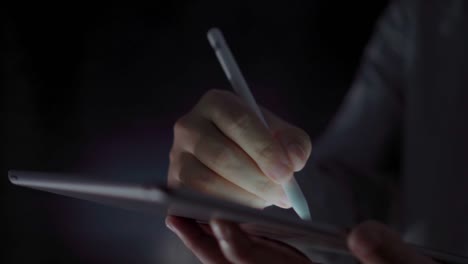 4K-Video-close-up-man-hand-using-pen-on-tablet-with-black-background.