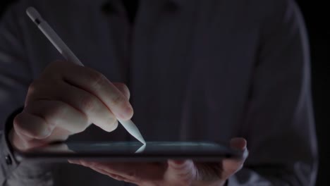 4K-Video-close-up-man-hand-using-pen-on-tablet-with-black-background.