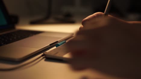 Close-up-view-of-graphic-designer-hand-using-graphics-tablet-working-over-night