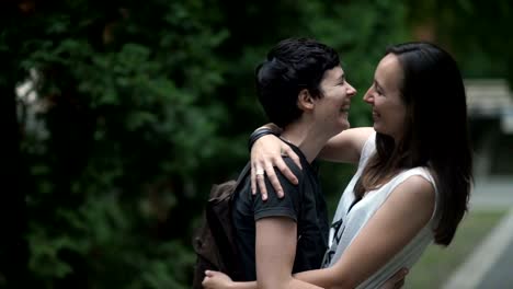 Two-happy-lesbians-talks,-hugs-and-kisses-in-park