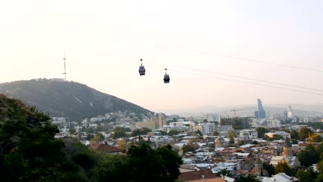 Stadt-Tbilisi-wird-lebendig-und-beschäftigt-in-den-Morgen,-Georgia,-Kabinen-kommen-durch-Seilbahn