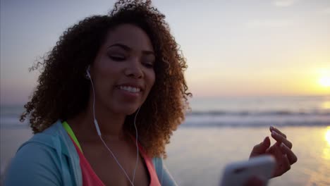 African-American-Frauen-tanzen-am-Strand-bei-Sonnenuntergang