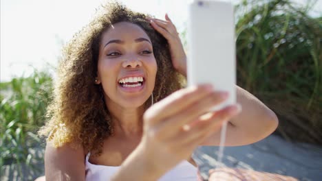 Mujer-afroamericana-con-teléfono-inteligente-en-la-playa