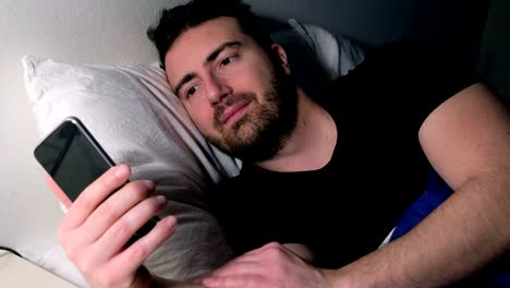 Man-using-mobile-phone-in-bed