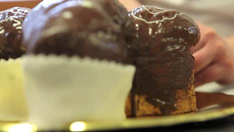 manos-de-chef-de-pastelería-decorar-Pascua-pasta-de-tortas-de-pan-dulce-con-azúcar-de-fondants,-closeup-en-la-encimera-en-confitería