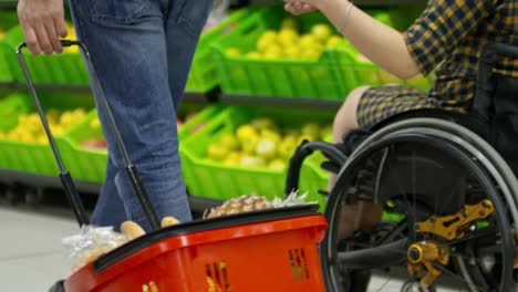 Frau-im-Rollstuhl,-die-Hand-in-Hand-mit-Mann-im-Supermarkt