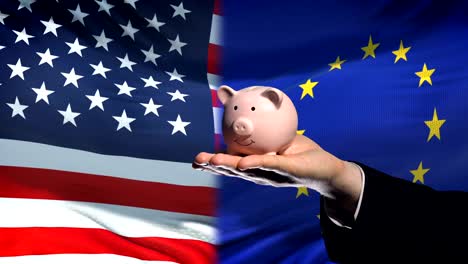 US-Investitionen-in-EU,-Hand,-Geld-im-Sparschwein-auf-Flagge-Hintergrund,-Finanzen