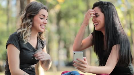 Candid-Girlfriends-looking-at-their-cellphone-outdoors-on-social-media