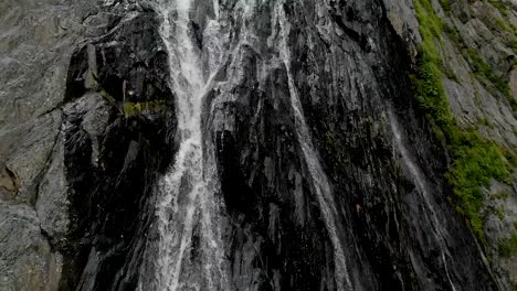 Tracking-und-oben-geschossen-Luft-aus-einem-Strom-von-Spritzwasser-Wasserfall-auf-einer-Felswand-in-den-Bergen-des-Kaukasus-gedreht.-Nahe-der-Jet-des-Wasserfalls