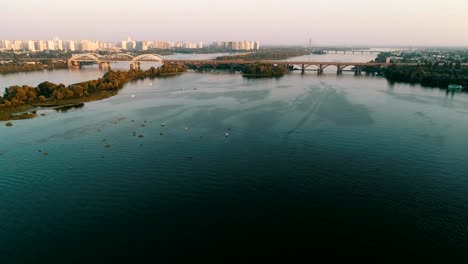 Luftaufnahme-der-Stadt-Kiew,-Ukraine.-Dnjepr-mit-Brücken.-Darnitskiy-Brücke.-Poznyaki-Bezirk-im-Hintergrund