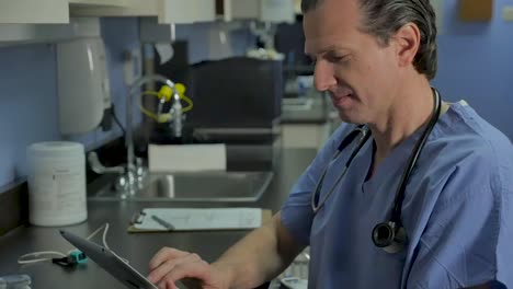 Male-nurse,-surgeon,-or-doctor-using-a-tablet-in-a-medical-practice