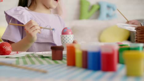 Feliz-chica-pintando-huevos-de-Pascua