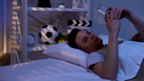 Teenager-tippen-auf-Smartphone-frühmorgens-im-Bett,-Gadget-Sucht