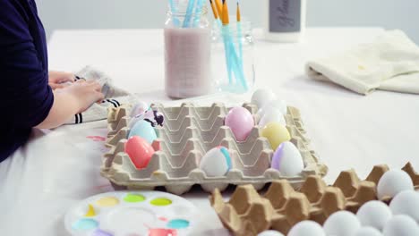 Niña-pequeña-pintando-huevos-de-Pascua-con-pintura-acrílica.