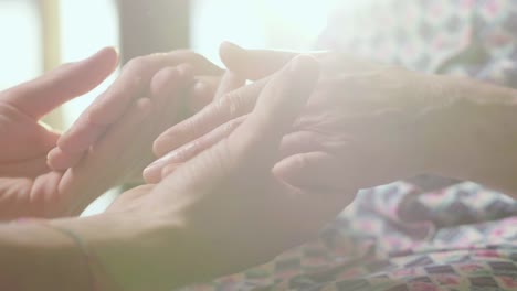 young-person-helps-her-grandmother-to-get-up-taking-her-hands.