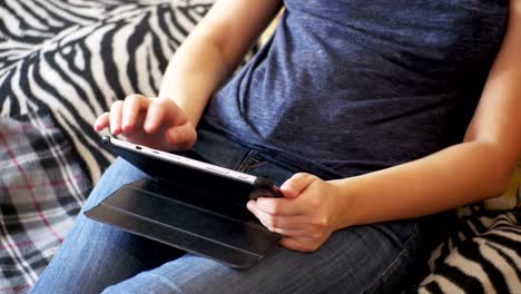 Mujer-joven-acostada-en-la-cama-y-usando-Tablet-en-casa