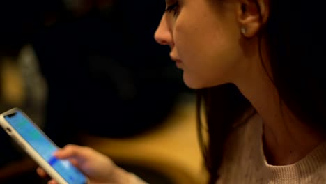 Pretty-female-drinking-coffee-and-chatting-with-friends,-holding-smartphone