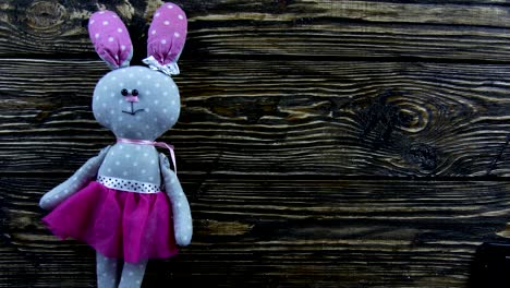 Toy-plush-hare-on-a-wooden-background