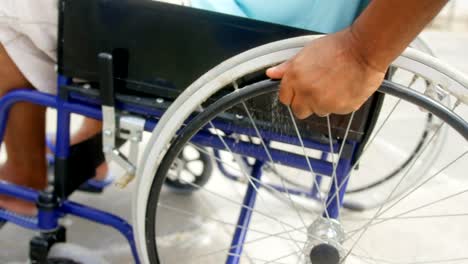 Close-up-of-disabled-active-senior-African-American-man-moving-his-wheelchair-on-promenade-4k