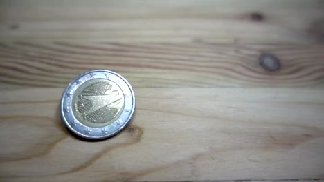 Cámara-lenta-de-rotación-de-monedas-euro-en-una-mesa-de-madera.