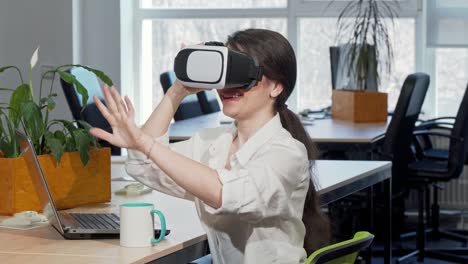 Lovely-excited-businesswoman-laughing-joyfully,-using-3d-virtual-reality-headset