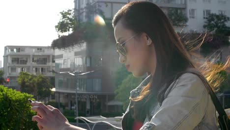 Joven-hermosa-mujer-usando-el-teléfono-en-el-balcón