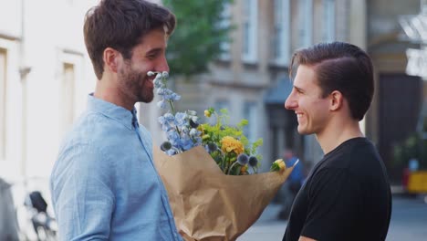 Liebenmännliche-Homosexuell-Paar-Treffen-auf-Datum-geben-Partner-Umarmung-und-Blumenstrauß