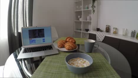 POV-der-Frau-Essen-Cornflakes-und-Video-auf-Laptop-ansehen