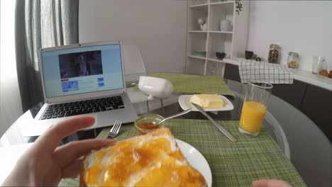 POV-von-Frau-Essen-Frühstück-und-Beobachten-Serie-auf-Laptop-zu-Hause