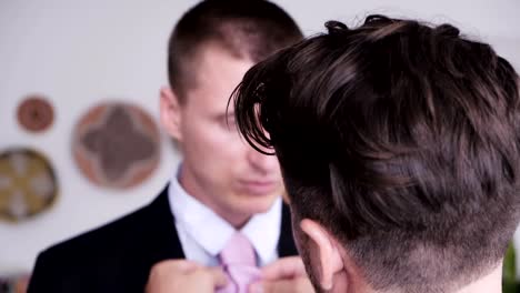 Gay-man-help-his-partner-putting-on-tie-for-job-interview.-Over-the-shoulder.