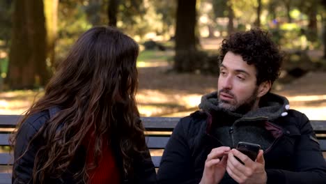 angry-woman-tearing-the-cell-out-of-her-boyfriend-hands-not-listening-outdoor