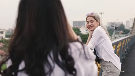 Asian-lesbian-couples-enjoying-traveling-using-film-camera-taking-a-photo.-Two-beautiful-young-women-having-fun-in-vacation-time.-LGBT-concept.