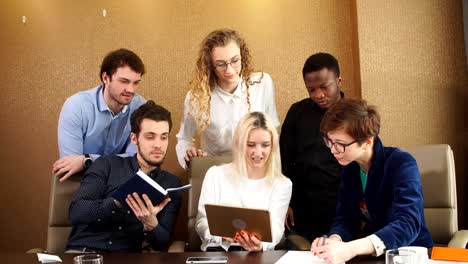 Blond-girl-showing-her-business-plan-to-co-workers