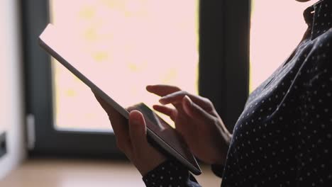 Vista-de-primer-plano-manos-femeninas-sosteniendo-la-información-de-búsqueda-de-gadgets-portátiles-de-la-tableta