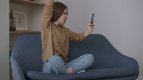 Geschäftsfrau-tippt-Nachricht-auf-Handy-im-Home-Office.-Junges-Mädchen,-das-in-Zeitlupe-telefoniert.-Schließen-Sie-junge-Frau-Hände-mit-Smartphone-auf-der-Couch.