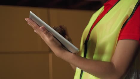 Close-up-on-a-African-american-woman's-Hands-Using-Digital-Tablet-Computer-while-Standing-in-the-Warehouse.