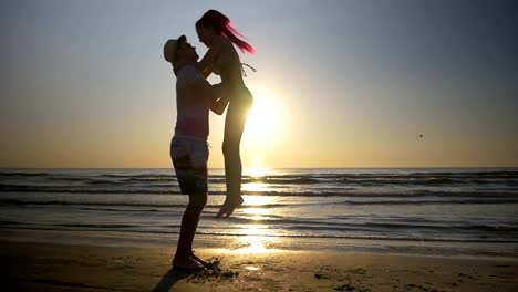 Couple-meeting-and-kissing-on-shore-and-woman-jumps-in-her-lover-arms-in-slow-motion