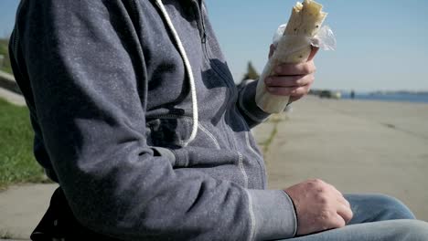 Disabled-man-in-wheelchair-eats-doner-kebab,-close-up,-portrait-lonesome-male-