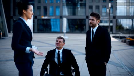 Entrepreneur-in-wheelchair-invalid-disabled,-but-very-happy-in-conversation-with-his-Colleagues