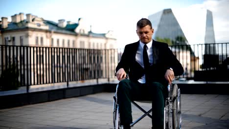 Disabled-businessman-trying-to-get-up-from-wheelchair-outdoor