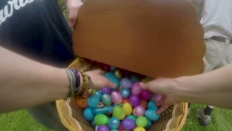 POV-of-a-woman's-hands-reaching-into-an-Easter-basket-and-grabbing-eggs