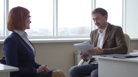 Paraplegic-Businesswoman-Talking-with-Coworker-and-Typing-on-Computer