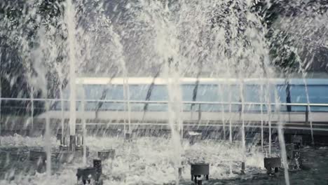 Der-Brunnen-in-der-Stadt-ist-close-up.-Wasserstrahlen-verlangsamt.-Stadtstraße-Sommer