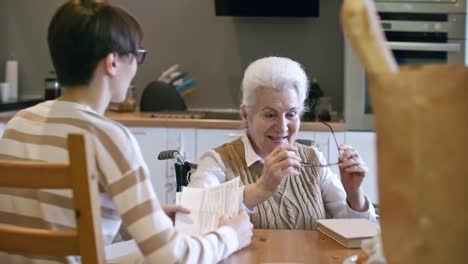 Junge-Frau-Lesung-Haushaltsrechnungen,-ältere-Dame