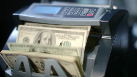 Modern-currency-counting-machine-counting-dollar-bills.-Paper-money-calculation