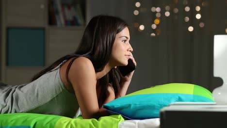 Teen-talking-on-phone-on-a-bed-at-home